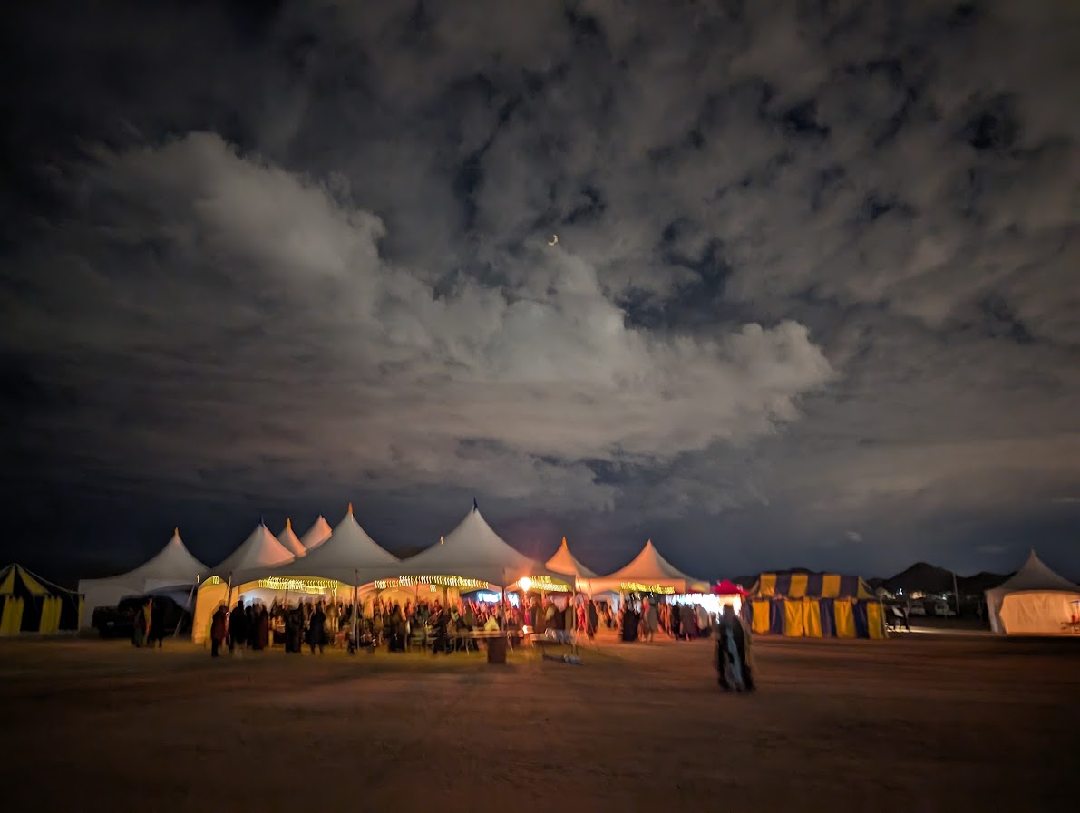 Graphic featuring people in medieval clothing participating in a lively nighttime activity involving a wooden wheel taken by Giovanni Salviati.